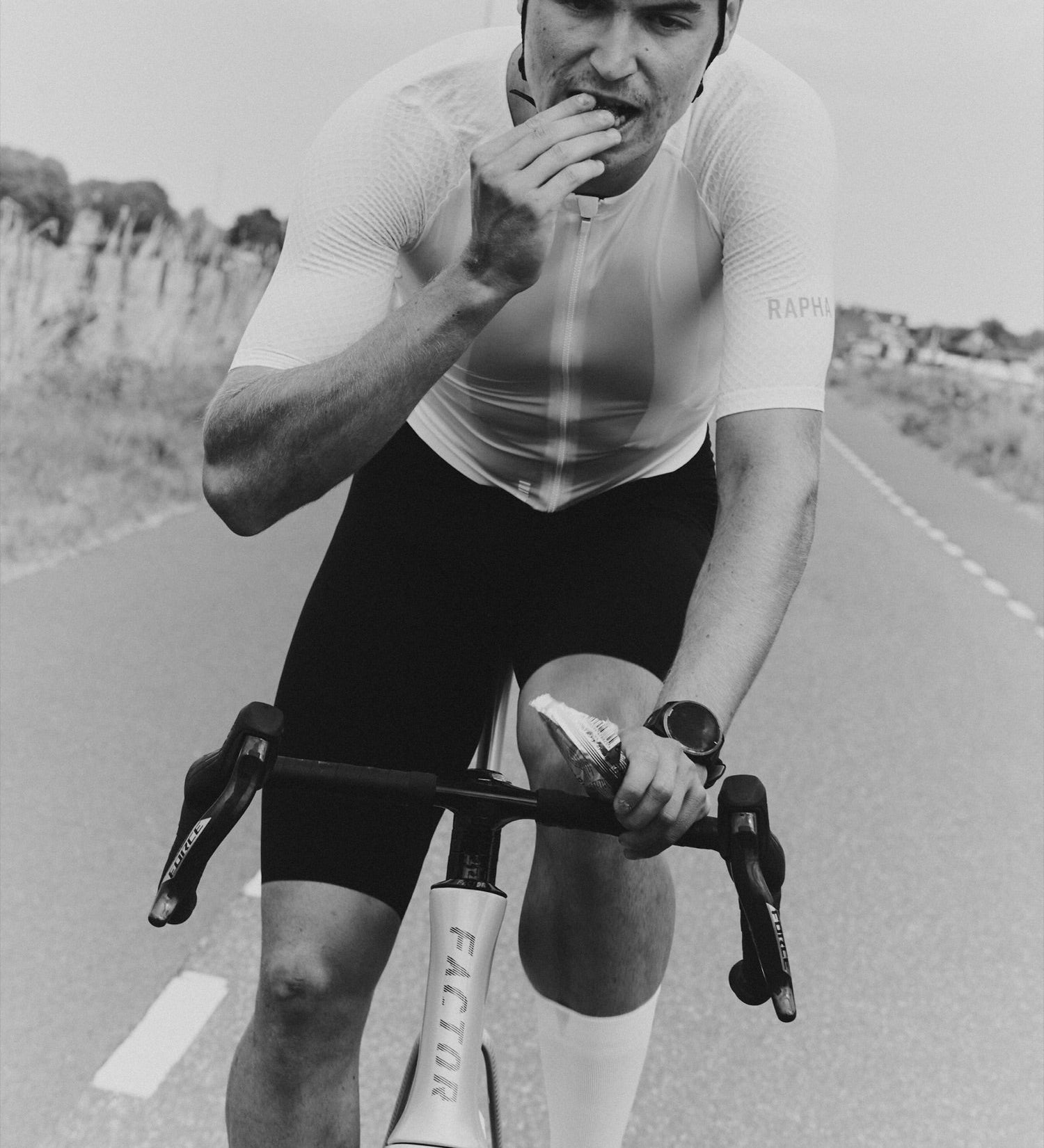 Cyclist in Rapha kit taking a GONNA Carb Chew mid-ride